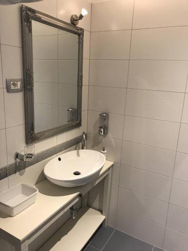 a white bathroom with a sink and a mirror at Pula Antic Rooms in Center in Pula