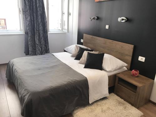 a bedroom with a large bed with a wooden headboard at Pula Antic Rooms in Center in Pula