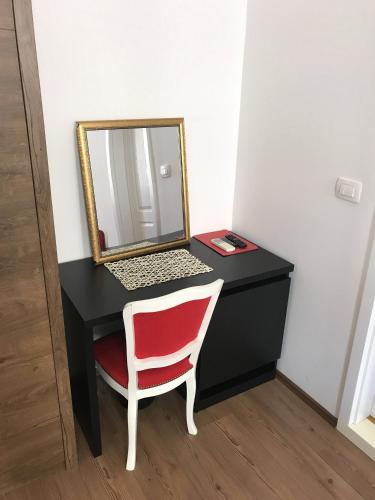 a desk with a red chair and a mirror at Pula Antic Rooms in Center in Pula