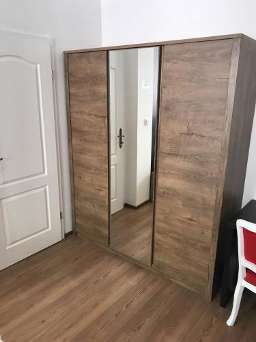 a large wooden sliding mirror in a room with a red chair at Pula Antic Rooms in Center in Pula