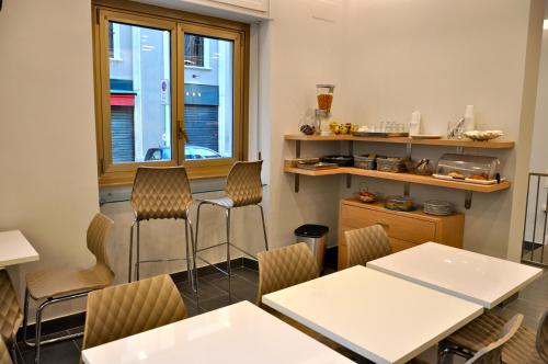 une salle à manger avec des chaises, des tables et une fenêtre dans l'établissement Hotel Dover, à Milan