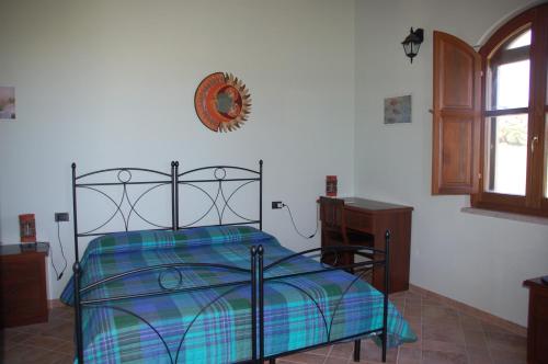 a bedroom with a bed and a table and a window at B&B Nuraximannu in Santadi