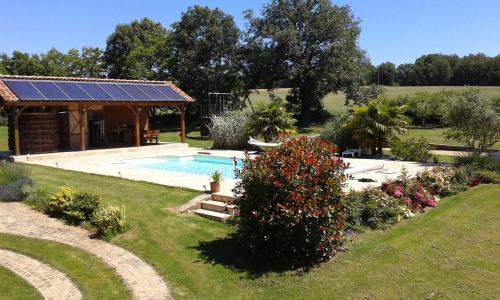 a garden with a swimming pool and a house at Gîtes de Lez in Laguépie