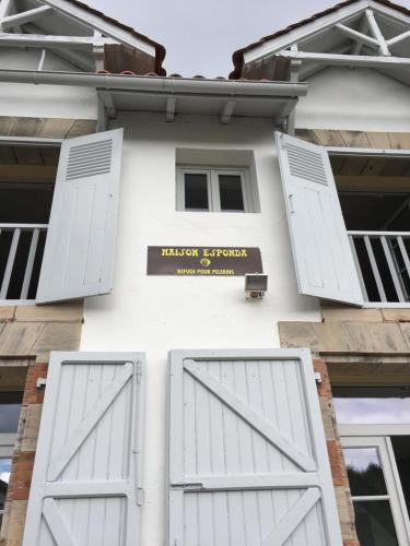 a building with white doors and a sign on it at La Villa Esponda in Saint-Jean-Pied-de-Port