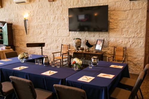 a room with blue tables and chairs and a tv at Joshua Creek Ranch in Boerne