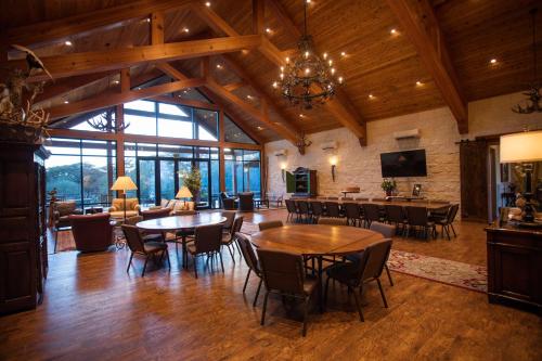 a large living room with wooden ceilings and tables and chairs at Joshua Creek Ranch in Boerne
