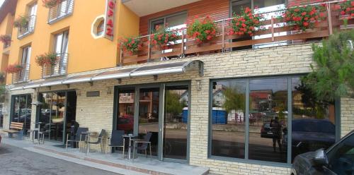 a brick building with tables and chairs on a street at Vila Topaz in Baile Felix