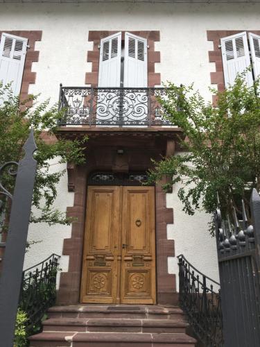 a house with a wooden door and a balcony at La Villa Esponda in Saint-Jean-Pied-de-Port