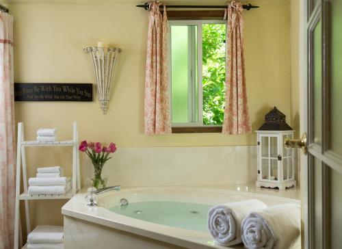 baño con bañera y ventana en Eagle Rock Lodge, en Vida