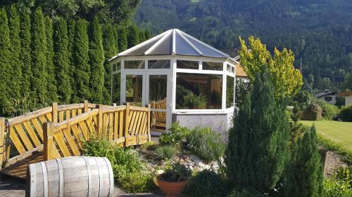 a gazebo in a garden with a fence at Apartmenthaus Kometerhof in Flattach