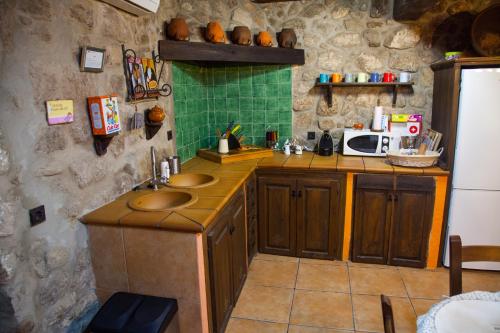 a kitchen with two sinks and a microwave at El Balcon de Los Sueños in Trevejo