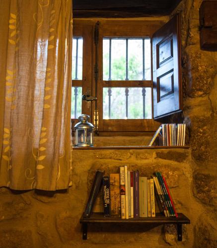 a shelf with books on it next to a window at El Balcon de Los Sueños in Trevejo