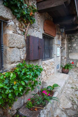 a stone building with a window and some plants at El Balcon de Los Sueños in Trevejo