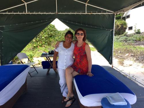 two women sitting on a bed in a tent at Beachfront Hammock Heaven in Akumal