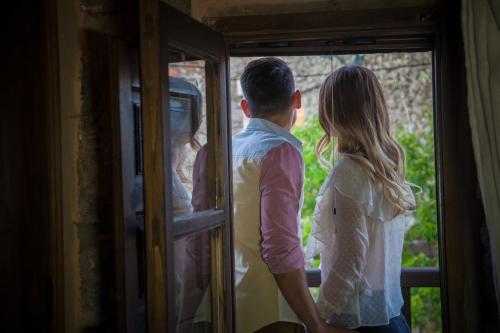 a man and a woman looking out of a window at El Balcon de Los Sueños in Trevejo