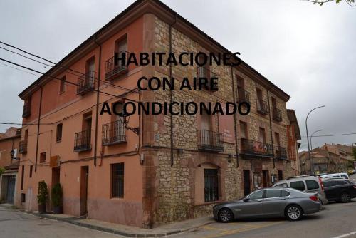 a building with a sign on the side of it at Hostal Mesón Castilla in Sigüenza