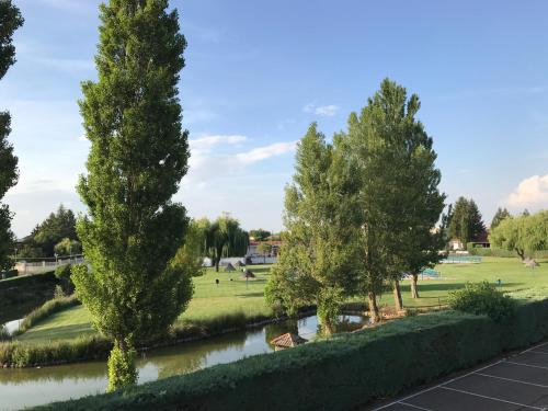 a view of a park with trees and a river at Hotel Valjunco in Valencia de Don Juan