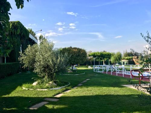 a park with a tree and a bridge at Hotel Valjunco in Valencia de Don Juan