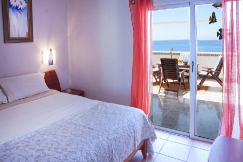 1 dormitorio con cama y vistas al océano en Beachfront apartment in paradise, en San Andrés