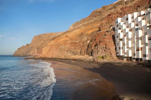 a building on the side of a cliff next to the ocean at Beachfront apartment in paradise in San Andrés