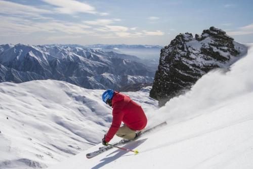 a person is skiing down a snow covered mountain at Cardrona Ski Apartment in Wanaka