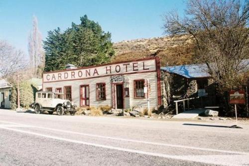 an old car parked in front of a carronic hotel at Cardrona Ski Apartment in Wanaka