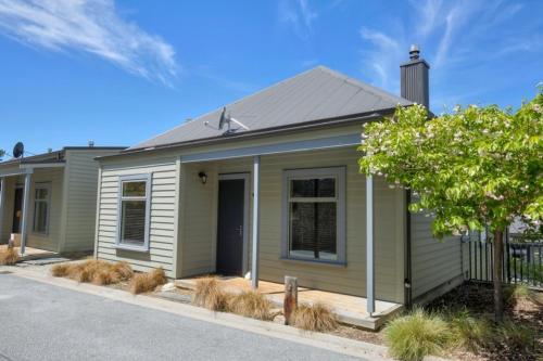 a small green house with a tree in front of it at Cardrona Ski Apartment in Wanaka