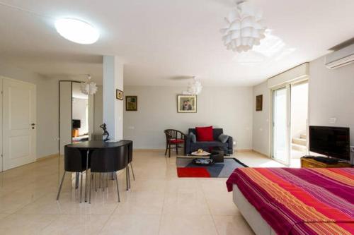 a bedroom with a bed and a living room with a table at Magnificent studio in Zichron yaakov sea view and garden in Zikhron Ya‘aqov