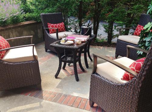 a patio with wicker chairs and a table and a table and chairs at Chambery Inn in Lee