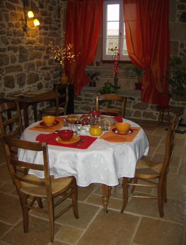 Una mesa de comedor con un mantel blanco y sillas. en Gîtes de Lez, en Laguépie