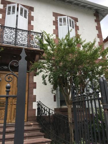 a house with a tree in front of a fence at La Villa Esponda in Saint-Jean-Pied-de-Port