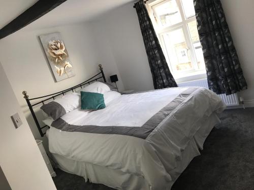 a bedroom with a large bed and a window at Wolds Cottage Pocklington in Pocklington