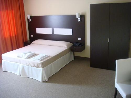 a bedroom with a bed with a black headboard at Santa Loja Hotel Residence in Tito