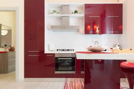 a kitchen with red cabinets and a white counter top at Apartment Home Marconi25 in Verona