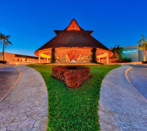 a large building with a clock on the front of it at Occidental at Xcaret Destination - All Inclusive in Playa del Carmen