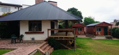 a small house with a wooden deck in the yard at Cabañas 57 in Villa Carlos Paz