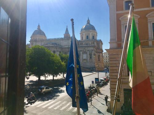 ローマにあるBasilica Hotelの建物の前に2つの旗が立っている