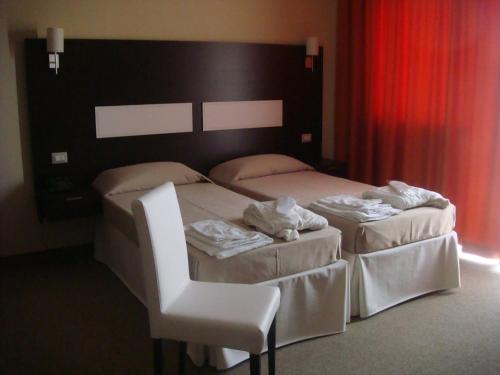 two beds in a hotel room with towels on them at Santa Loja Hotel Residence in Tito