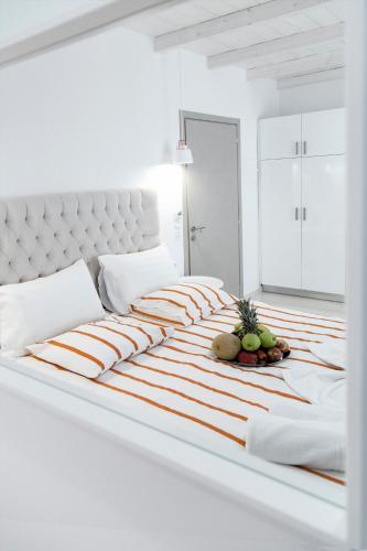 a white bedroom with a large bed with fruit on it at Liberte Maisonettes in Parga