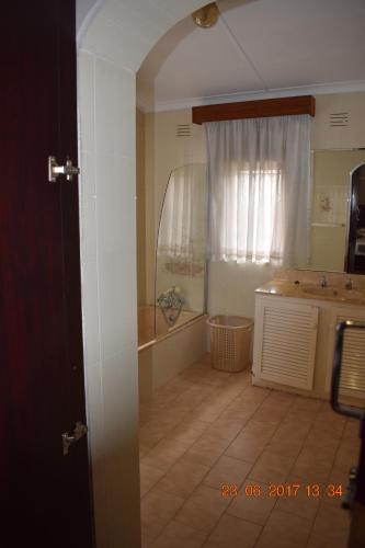a bathroom with a tub and a sink and a window at Clycherco Self Catering in Durban