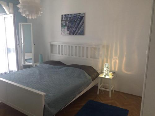 a bedroom with a bed and a table with a lamp at Apartments Rube in Primošten