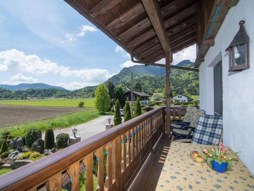 a balcony with a table and chairs and mountains at Ferienwohnungen Blos in Grassau