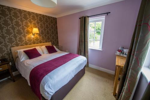 a bedroom with a bed and a window at The Grove in St. Davids