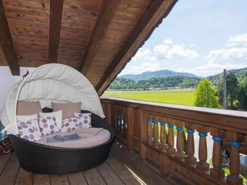 a wicker chair sitting on a deck with a view at Ferienwohnungen Blos in Grassau