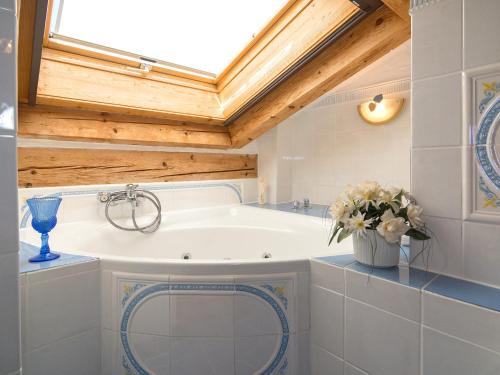 a bath tub in a bathroom with a skylight at Ferienwohnungen Blos in Grassau