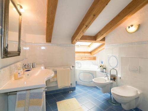 a bathroom with a sink and a toilet and a tub at Ferienwohnungen Blos in Grassau
