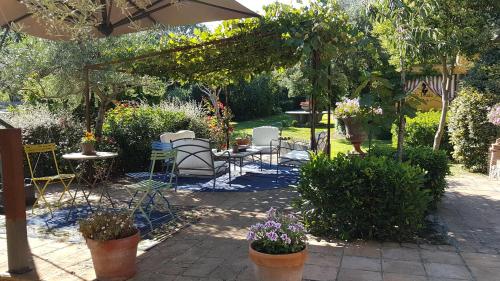 a patio with tables and chairs in a garden at Piccolo Feudo Green Resort in Viterbo