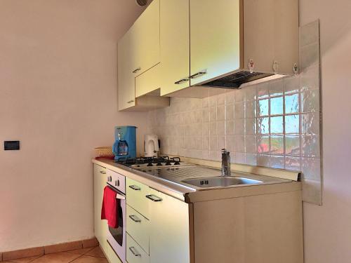 a kitchen with white cabinets and a sink at Residence Bellavista in Manerba del Garda