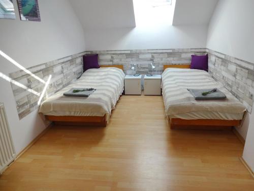 two beds in a small room with a sink at Albízia Apartments in Balatonfüred