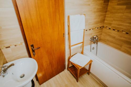 a bathroom with a sink and a toilet and a bath tub at Kavalliera Pensiune in Cotormani